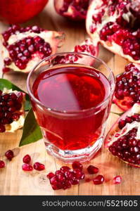 glass of pomegranate juice with fresh fruits on wooden table