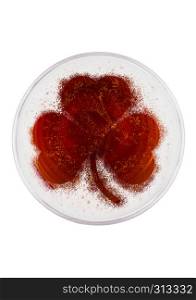Glass of red ale beer top with shamrock shape on white background top view