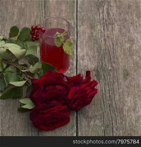 glass of red juice, currant and bouquet of roses, subject of berry and drinks