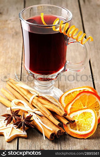 Glass of red mulled wine on wooden table