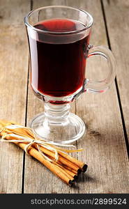 Glass of red mulled wine on wooden table