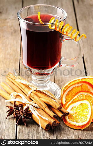 Glass of red mulled wine on wooden table