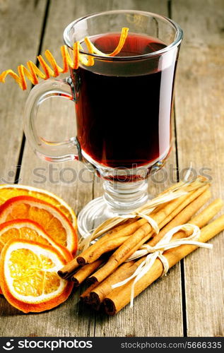 Glass of red mulled wine on wooden table