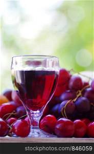 Glass of red wine and fruits on a wooden table
