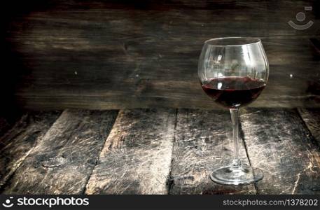 glass of red wine. On a wooden background.. glass of red wine.