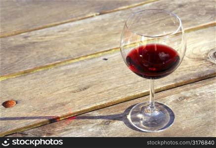 Glass of red wine on old rustic table