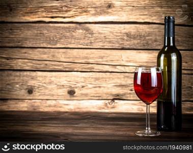 Glass of red wine on the table. On a wooden background. . Glass of red wine on the table.