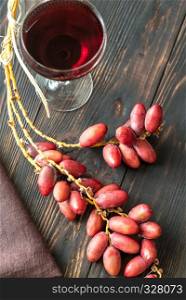 Glass of red wine with bunch of dates