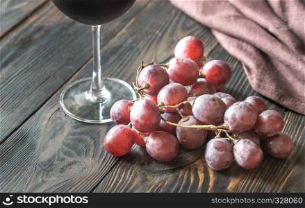 Glass of red wine with bunch of red grape
