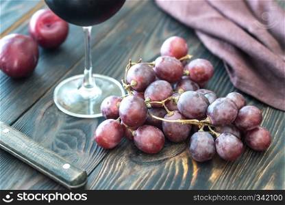 Glass of red wine with bunch of red grape