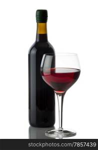 Glass of red wine with full bottle in background on white with reflection