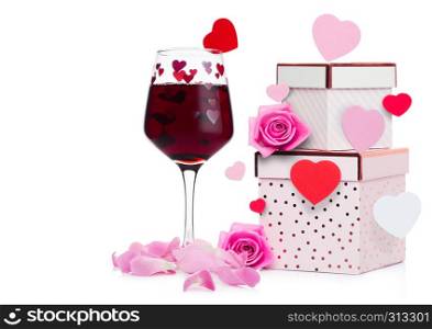 Glass of red wine with heart and pink gift box and rose for valentine's day on white background with flying heart