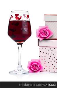 Glass of red wine with heart and pink gift box and rose for valentine's day on white background