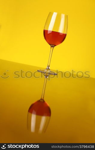 Glass of rose wine over a yellow background