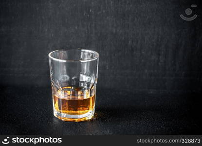 Glass of rum on the dark background