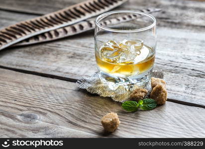 Glass of rum on the wooden background