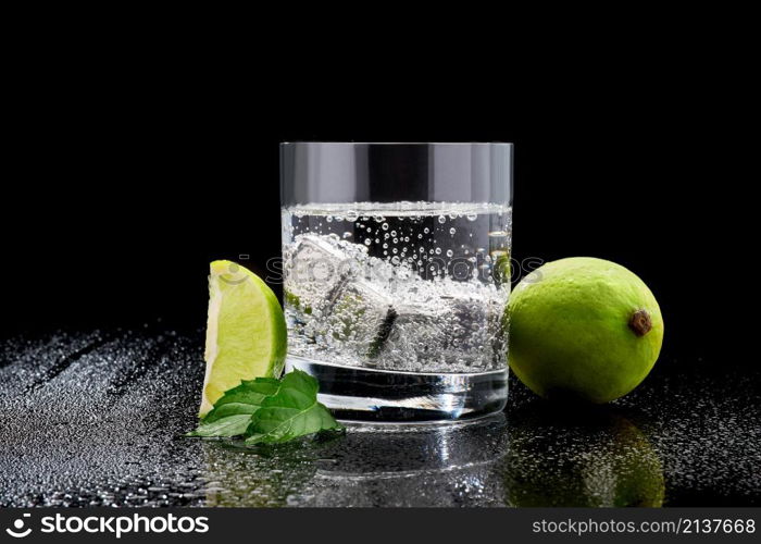 Glass of Soda or Coctail with steel cooling cubes on dark glass background.. Glass of Soda or Coctail with steel cooling cubes on dark glass background