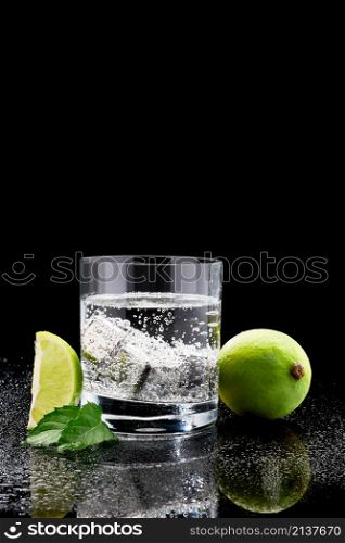 Glass of Soda or Coctail with steel cooling cubes on dark glass background.. Glass of Soda or Coctail with steel cooling cubes on dark glass background