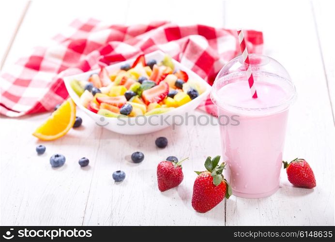 glass of strawberry smoothie on wooden table