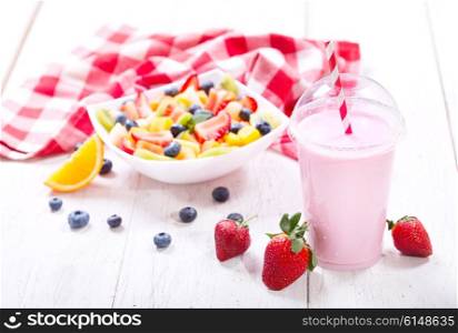 glass of strawberry smoothie on wooden table