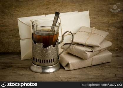 glass of tea and post envelopes on the wooden background
