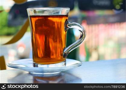 Glass of tea on table with blurred window in background