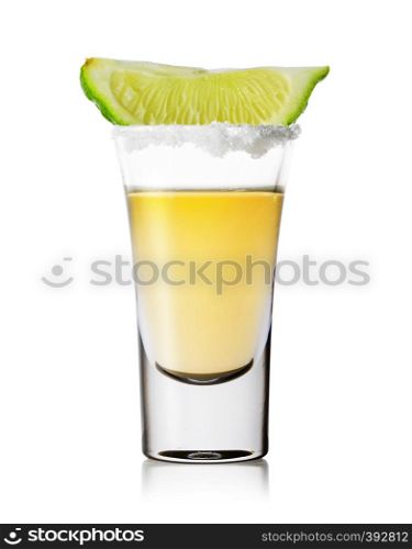 Glass of tequila with salt on the rim and a slice of lime isolated on a white background. Gold tequila. Traditional strong alcoholic Mexican drink.. Glass of tequila with salt on the rim and slice of lime