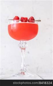 Glass of The Blinker Cocktail garnished with raspberries