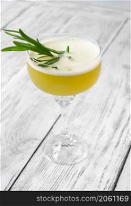 Glass of Ultima Palabra cocktail garnished with fresh rosemary