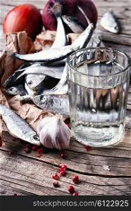 Glass of vodka,smoked sprat,spices in a rustic traditional russian style