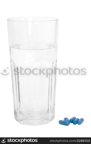 Glass of Water and Blue Pills on white background