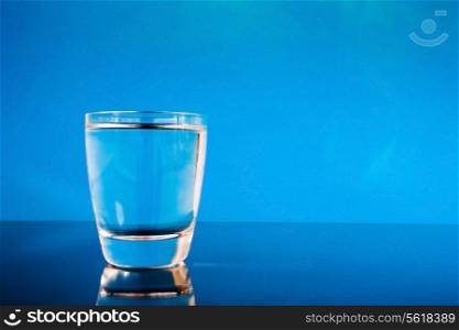 Glass of water on a reflective surface