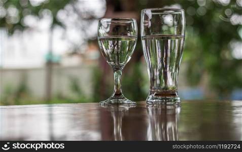 Glass of water placed on a wooden table.