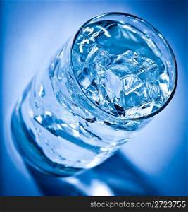 Glass of water with ice on a dark blue background