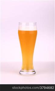 Glass of wheat beer over a light background