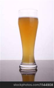 Glass of wheat beer over a white background