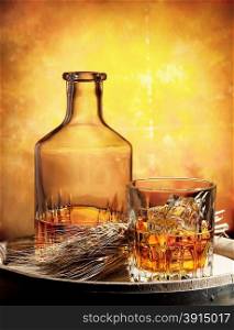 Glass of whiskey decanter and ears of wheat on a wooden barrel