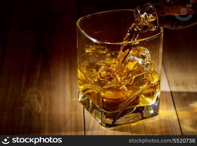 glass of whiskey on wooden table