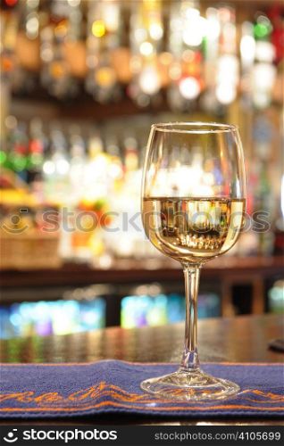 glass of white wine on a bar inside a pub