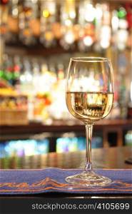 glass of white wine on a bar inside a pub