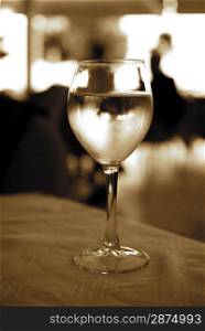 Glass of white wine on a table (toned in sepia)