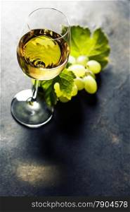 Glass of white wine on dark background