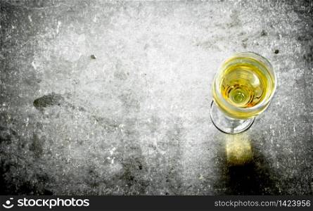 glass of white wine. On the stone table.. glass of white wine.