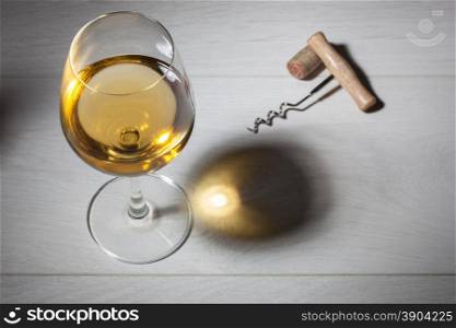 Glass of white wine on wooden table. Top view