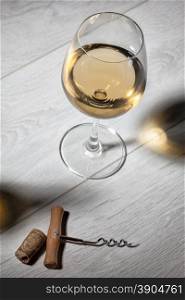 Glass of white wine on wooden table. Top view