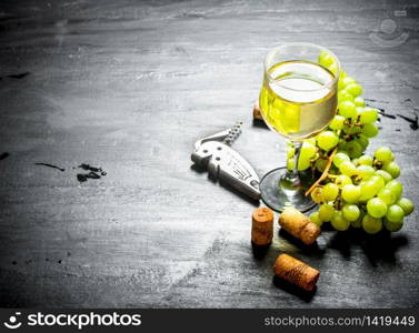 glass of white wine with corks and bunch of white grapes.. Fresh white wine