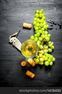 glass of white wine with corks and bunch of white grapes.. Fresh white wine