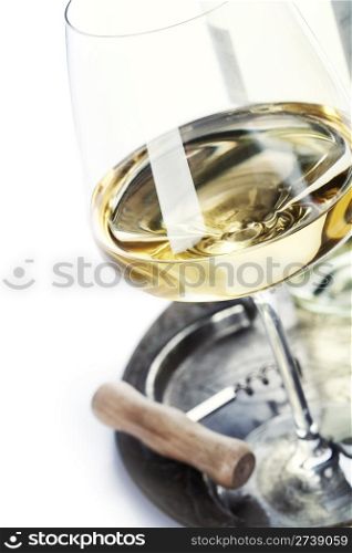 glass of wine and corkscrew over white