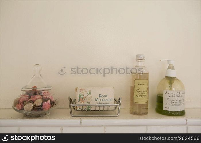 Glass pot of pot potpouri on a shelf next to a soap dish and lavender gel