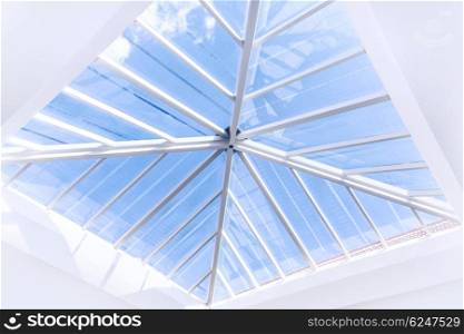 Glass roof modern interior design,b abstract background, window in ceiling, luxurious tall building with view on blue sky, contemporary architecture